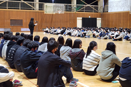 岡谷南高校の対面式で、新入生代表が挨拶をしている場面。3学年全員が揃い、南高生としての新たな日常をスタートさせる生徒たちの後ろ姿。