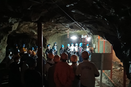 岡谷南高校の平和学習にて、薄暗い象山地下壕の内部をヘルメット姿で見学し、当時の過酷な環境や歴史的背景を肌で感じる生徒たちの様子。