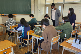 岡谷南高校の教室にて、ALTの先生や担当教師が見守る中、グループに分かれて台湾の生徒とオンライン交流を楽しむ英語部員たち。