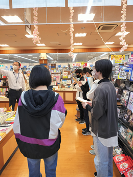 岡谷南高校の図書委員が笠原書店を訪れ、店長から「売れている本」や「売るべき本」についての説明を熱心に聞いている選書体験の様子。