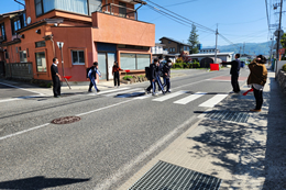 岡谷南高校の交通安全街頭指導の様子。見通しの良い道路の交差点や横断歩道に職員と生活委員が立ち、登校する生徒に挨拶をしながら交通マナーを確認している風景。