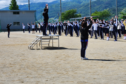 岡谷南高校のグランドにて、クラスマッチの怪我予防のために一斉に準備体操を行う全校生徒の風景。