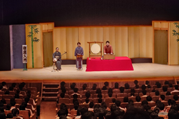 岡谷南高校の芸術鑑賞会。ステージ上で三味線、太鼓、笛などの下座音楽について、実演を交えながら解説を聞く全校生徒の様子。