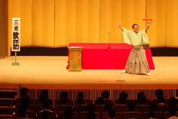 岡谷南高校の芸術鑑賞会。和傘の上で独楽（こま）を回す「曲ごま」の妙技に、会場全体が大きく盛り上がるステージパフォーマンスの様子。