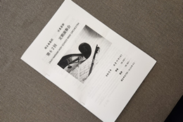 岡谷南高校吹奏楽部・定期演奏会のプログラム。白地に楽器のイラストが描かれた、第62回公演の案内冊子のアップ。