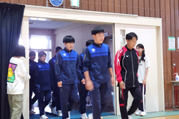 岡谷南高校の北信越大会壮行会。全校生徒の拍手に迎えられ、ユニフォーム姿で堂々と体育館に入場する陸上部と漕艇部の選手たち。