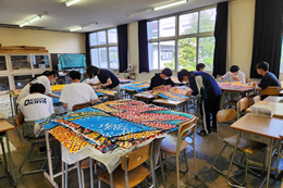 岡谷南高校の南高祭準備。教室で机を並べ、クラス展示に使用する大きな装飾物や背景を協力して制作する生徒たち。
