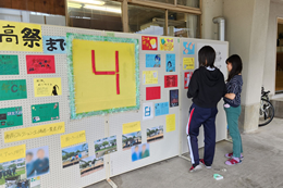 岡谷南高校の校内に設置された「南高祭まであと4日」を示すカウントダウンボードと、準備の打ち合わせをする生徒。