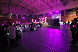 岡谷南高校の南高祭前夜祭。紫色の鮮やかな照明に照らされた体育館で、熱気あふれる開会を待つ全校生徒の様子。