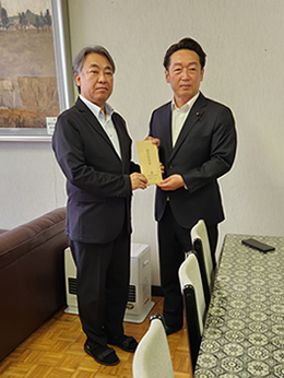 岡谷南高校にて、同窓会の共田会長から藤澤校長へ「教育振興費」が手渡される様子。生徒の活動支援のための寄贈に対する感謝の場。