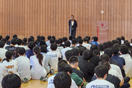 岡谷南高校の全校集会で挨拶をするALTの先生