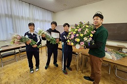 岡谷南高校でJA信州諏訪から寄贈されたフラワーアレンジメントを受け取る様子