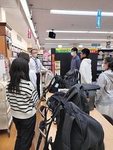 岡谷南高校の図書委員が笠原書店で店長の説明を聞く様子