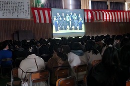 岡谷南高校の壮行会でスクリーンを使って活動紹介を行う様子