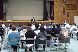 岡谷南高校のPTA総会で体育館に集まり説明を聞く保護者