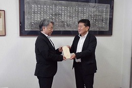 岡谷南高校の教育振興費贈呈式で同窓会代表から学校へ目録が手渡される様子