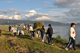 岡谷南高校 諏訪湖周辺の清掃活動で湖岸を歩きながらごみを拾う生徒