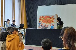 岡谷南高校 市立岡谷図書館子ども読書まつりで大型紙芝居の読み聞かせを行う生徒