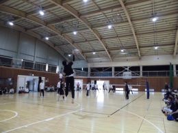 岡谷南高校の体育館で、高い打点から鋭いスパイクを放つ男子バレーボールの熱戦の瞬間