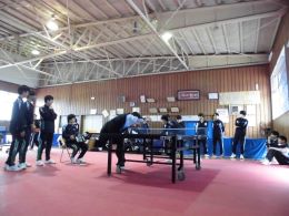 岡谷南高校の卓球場にて、真剣な表情で力強いスマッシュを打ち込む男子卓球の対戦風景