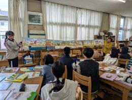 岡谷南高校の絵本講座で、横に長く広がる仕掛け絵本など様々な種類の本について説明を受ける様子
