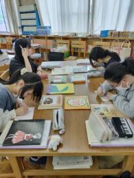 岡谷南高校の図書室にて、講座の内容をメモしたり絵本についてのワークに取り組んだりする生徒たち