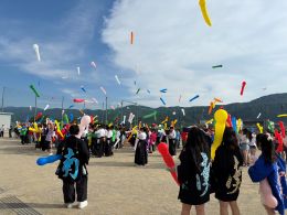 岡谷南高校の青空の下、一斉に放たれた色とりどりのジェット風船が舞う様子