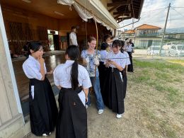 岡谷南高校 国際交流（マウントプレザント市との交流会）弓をふくのに苦戦している様子