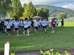 岡谷南高校 第44回諏訪縦断強歩大会 男子生徒らが青い草原の上を走っている様子