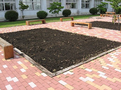 岡谷南高校：黒土が入れられ、苗を植える準備が整った中庭の四角い花壇スペース。