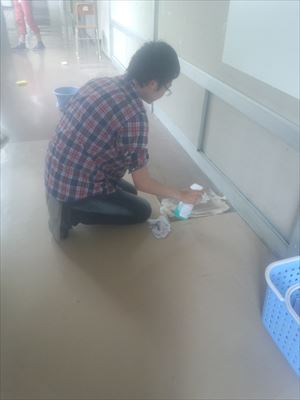 岡谷南高校：ロッカー周辺や壁際などの細かい箇所を、生徒が手作業で一つひとつ丁寧に清掃し、汚れを落としている作業風景。